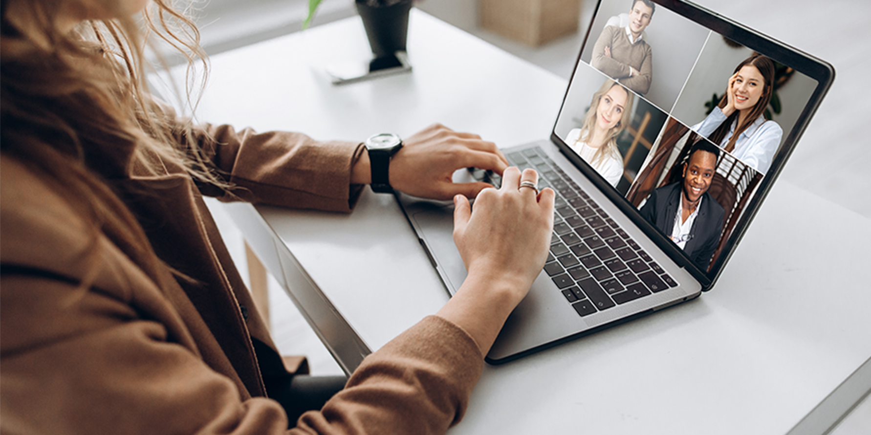 Photograph of a sales leader on a video call with four others on a laptop