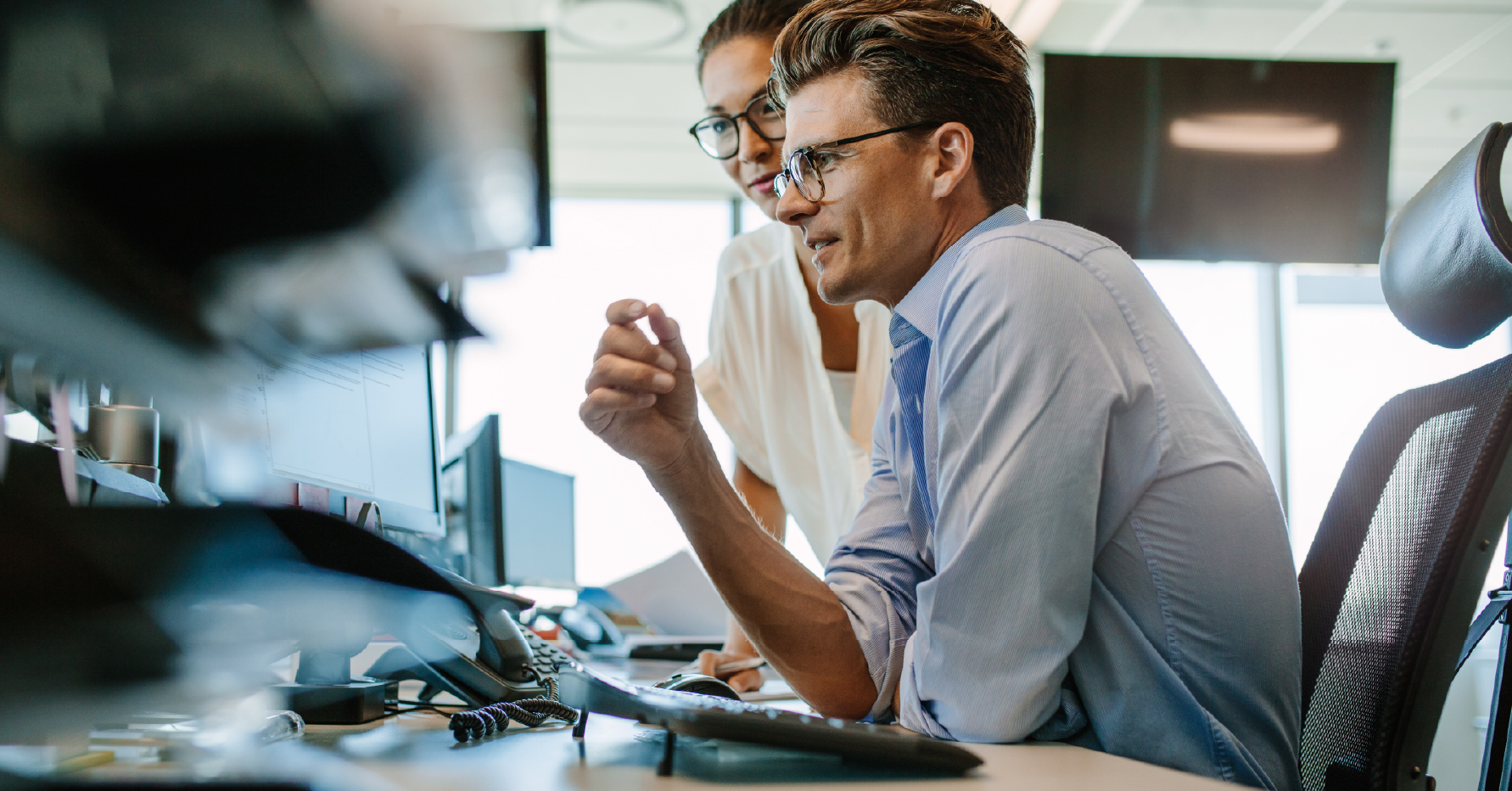 Photograph of a sales engineering leader looking at reports on a computer screen