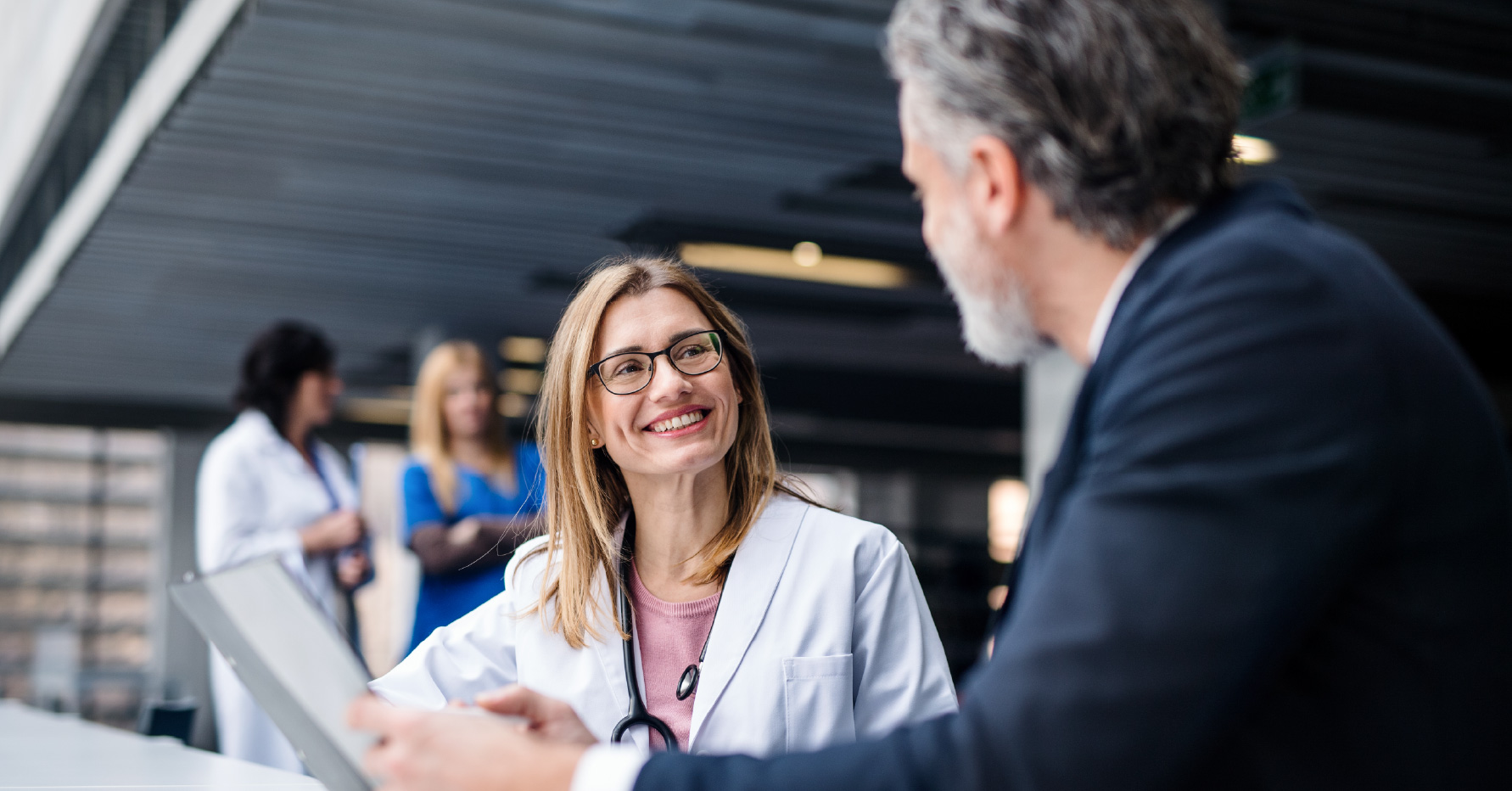 Photograph of a medical device salesperson talking to a healthcare professional