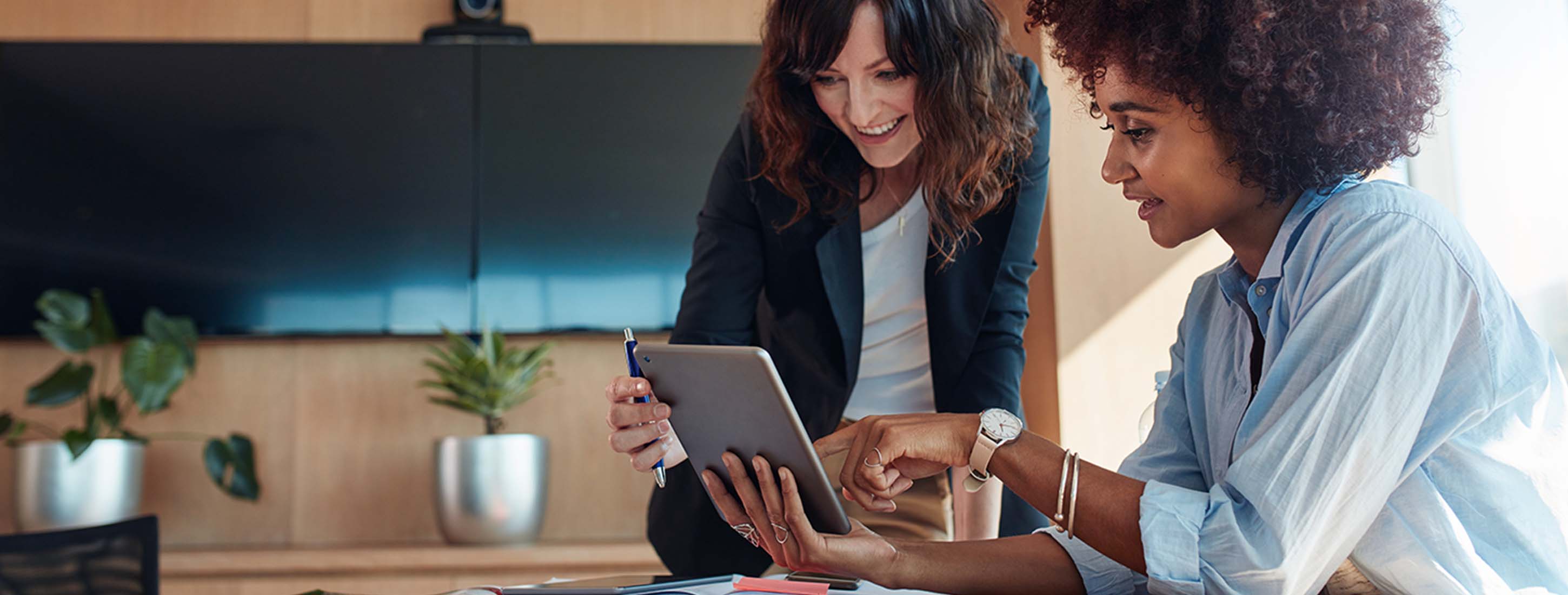 Photograph of two revenue leaders looking at a mutual action plan on their tablet