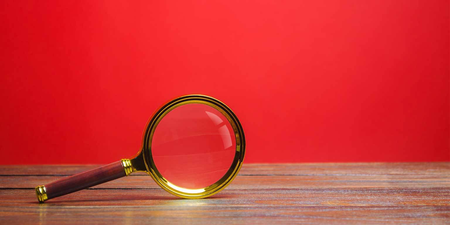 Photograph of a magnifying glass balancing on its side on a table