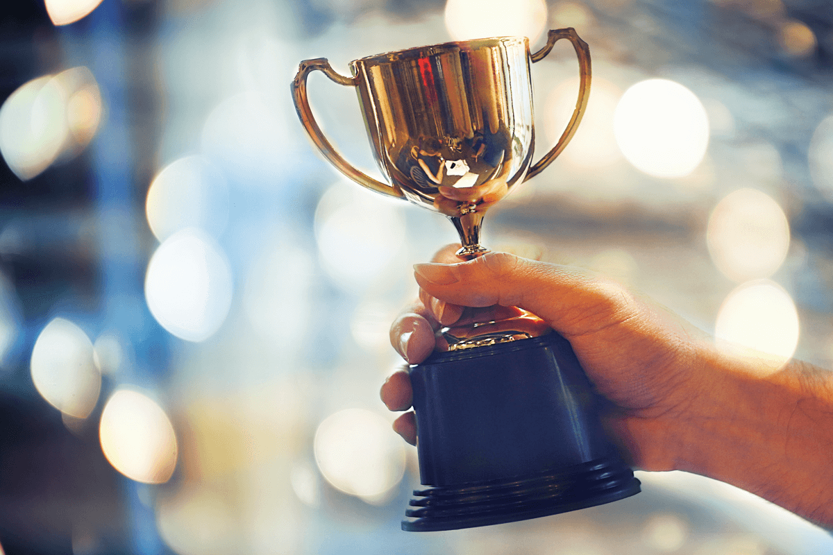 Photograph of a hand holding a golden trophy