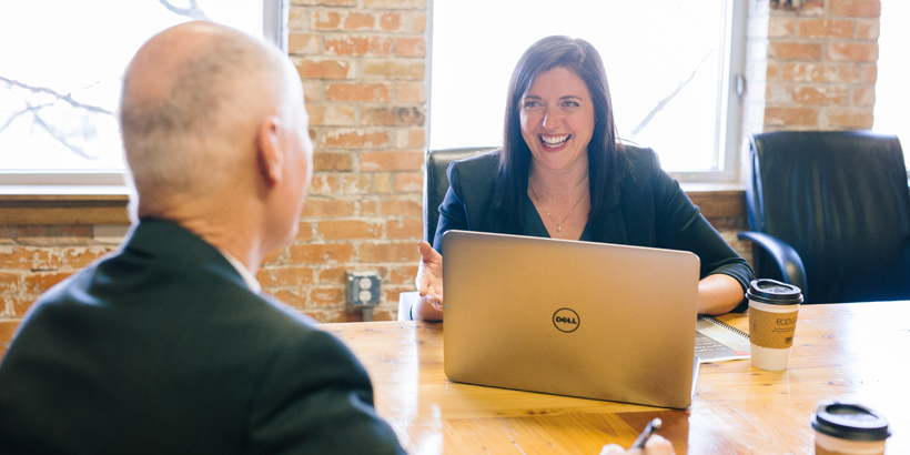 Photograph of two revenue leaders sitting at a desk and strategizing how to close more deals faster 