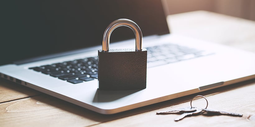 Photograph of a padlock on top of a laptop next to a set of keys