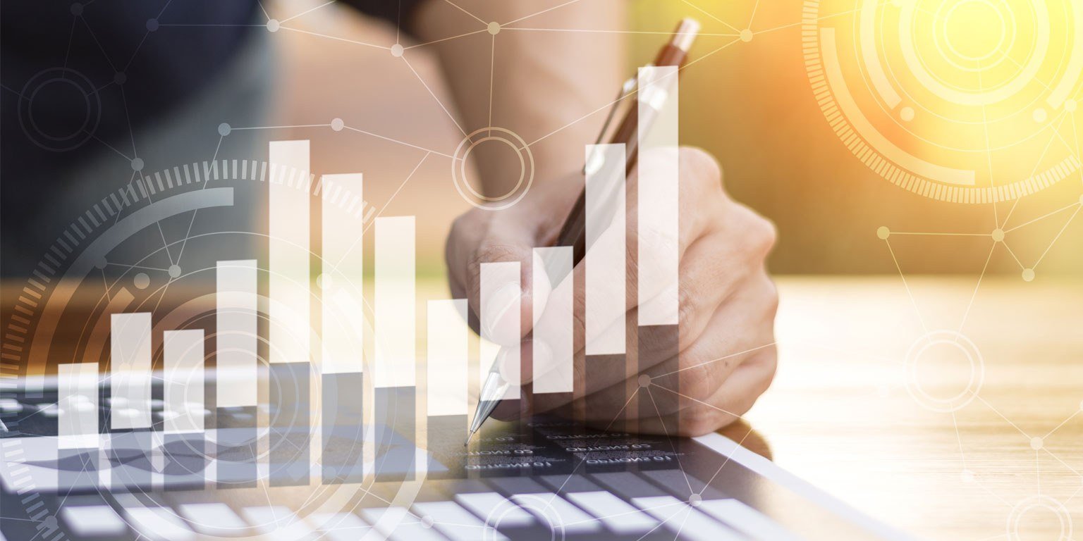 Stylized photograph of a hand holding a pen under an overlapping graphic of a bar chart