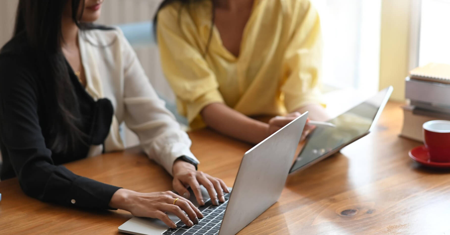 Two women working on laptops