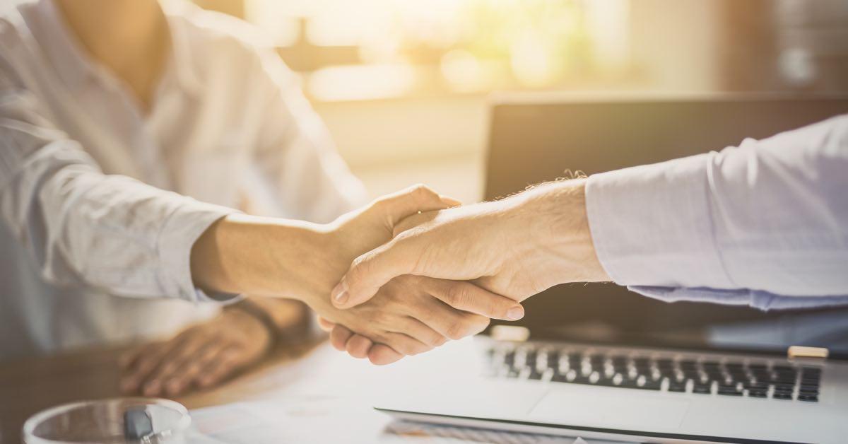 Photograph of two sales people shaking hands