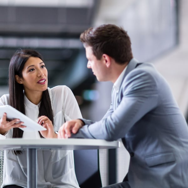 Photograph of two revenue professionals discussing a report on a tablet