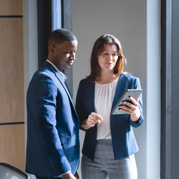 Photograph of two financial services leaders looking at a Clari report on a tablet