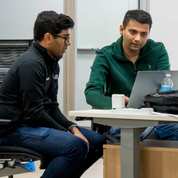 Photograph of two revenue team professionals looking at a laptop screen in an office