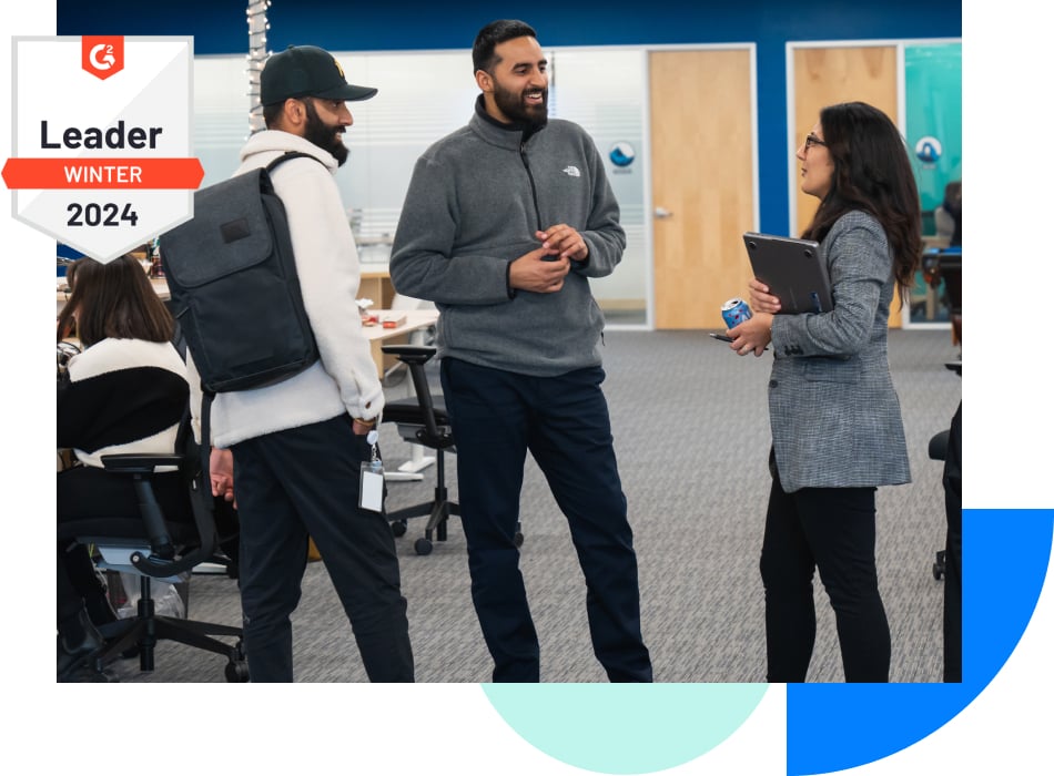 Photograph of three revenue professionals talking in an open-plan office